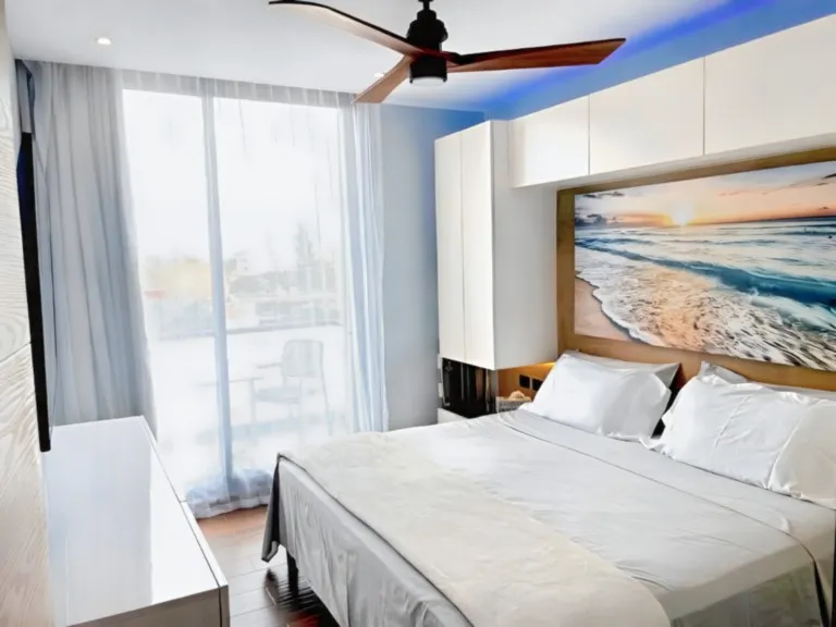 Bright modern bedroom with king-size bed and natural light in Playa del Carmen apartment