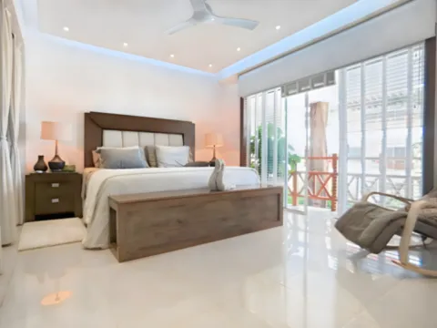 Un dormitorio elegante y luminoso diseñado para disfrutar de confort y tranquilidad Dormitorio amplio y luminoso con cama doble y acceso directo al balcón en Playa del Carmen